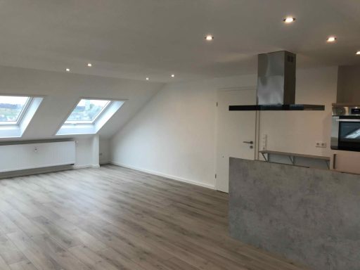 Helle, moderne Wohnung mit Dachfenstern und offenem Wohnbereich.