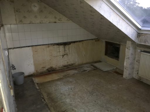 Leere, ungepflegte Räume mit abblätternder Wandverkleidung und sichtbarem Bodenbelag.