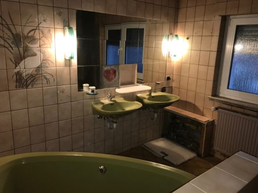 Badezimmer mit zwei grünen Waschbecken, Badewanne und Fenster mit Blende.